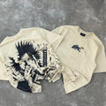 Beige streetwear t-shirts with anime samurai graphic and sword design, laid on concrete