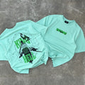 Mint green graphic t-shirts with anime swordsman and 'King of Hell' text, laid on gray floor.