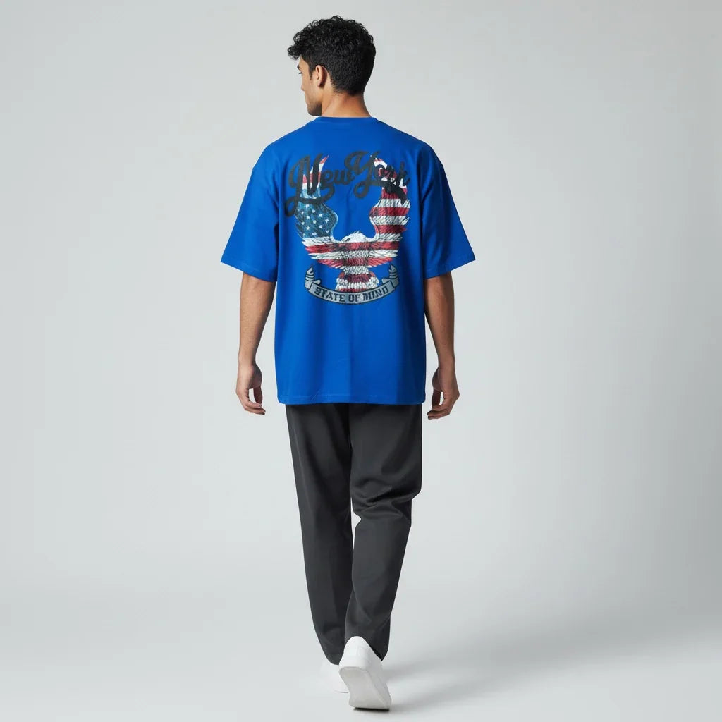 Man wearing blue graphic oversized t-shirt with eagle and USA flag print on back