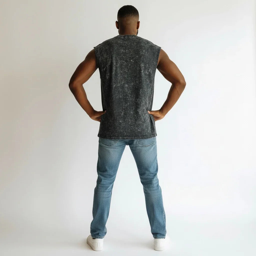 Man wearing sleeveless acid wash black shirt and blue jeans, back view, casual fashion