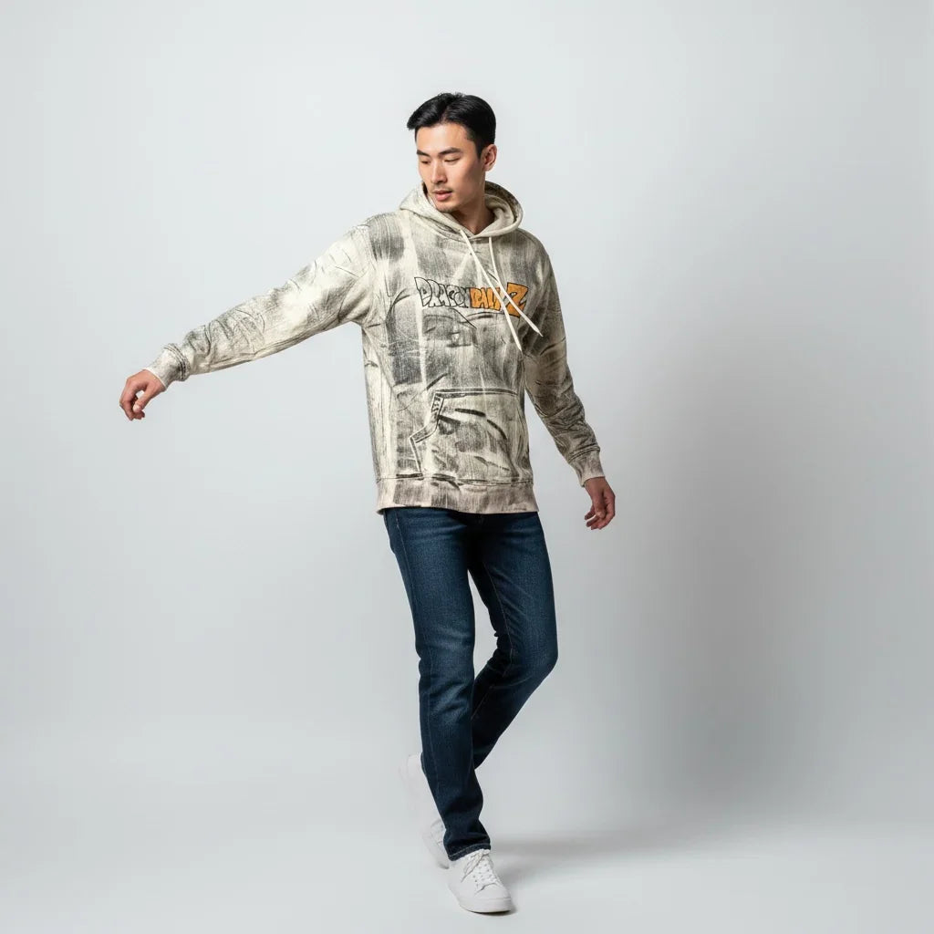 Man wearing graphic print hoodie, blue jeans, and white sneakers on a plain background