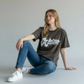 Woman in casual streetwear, wearing a graffiti print dark t-shirt and blue jeans