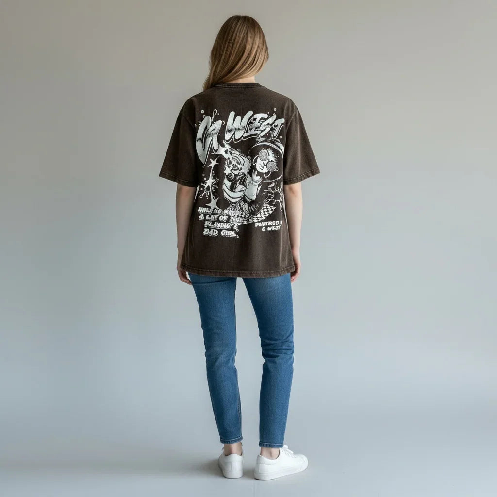Woman wearing oversized graphic t-shirt with cartoon print, blue jeans, and white sneakers