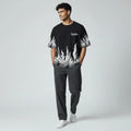 Man wearing black graphic flame t-shirt with 'Legendary' text, dark pants, white sneakers