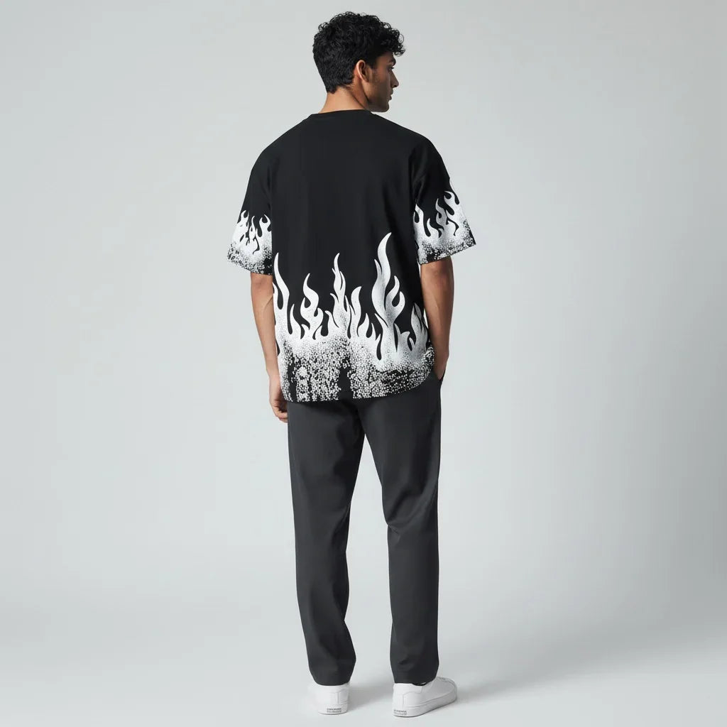 Man wearing black t-shirt with white flame graphic, dark pants, and white sneakers, rear view