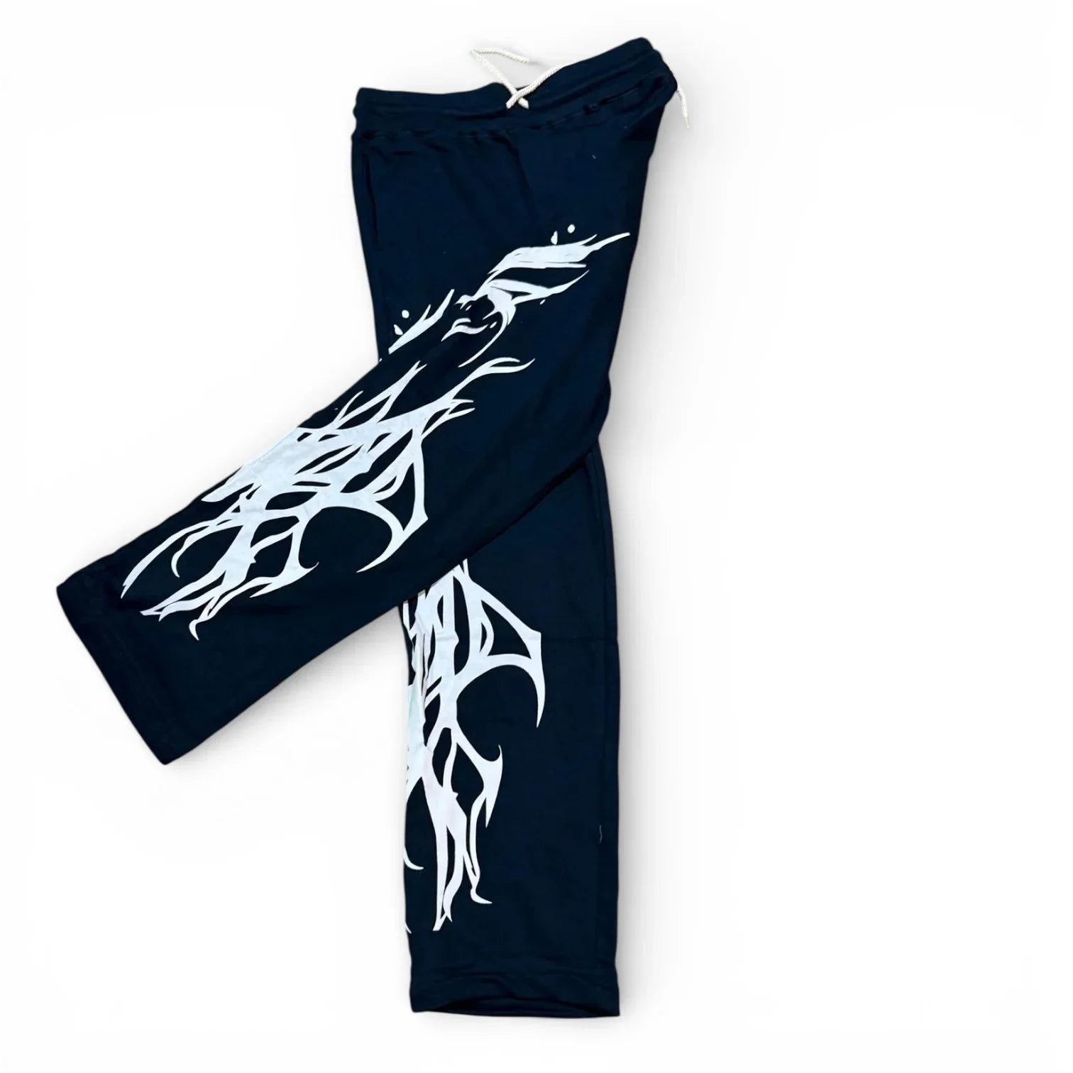 Black sweatpants with bold white abstract graphic design on the legs, streetwear style