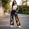 Woman in black flame print sweatpants and white crop top posing outdoors, street style fashion